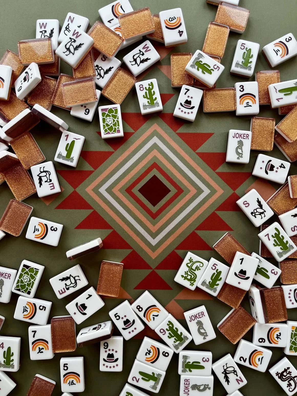 Mahjong tiles scattered around a patterned mat
